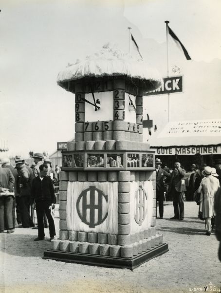 Spectators gather around a clock tower constructed of twine at the exhibition of the German Agricultural Society in Cologne, Germany. The exhibition took place from May 27 to June 1. The clock was part of an exhibit prepared by International Harvester's Neuss branch house, and promoted the company's binder twine production.