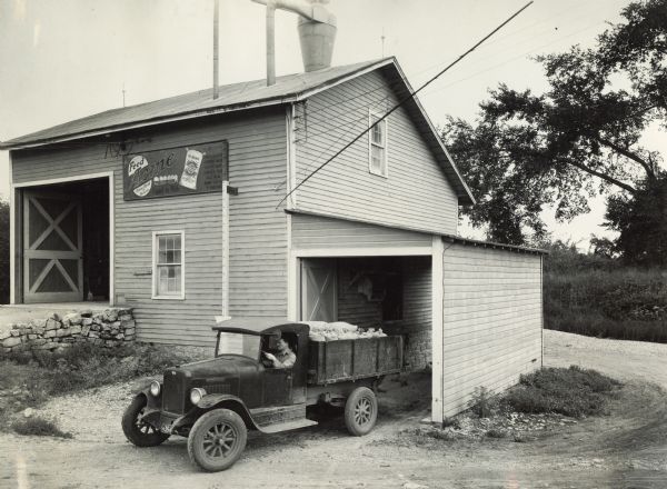 A man leaves the Acme feed mill with a truckload of wheat and grain.
