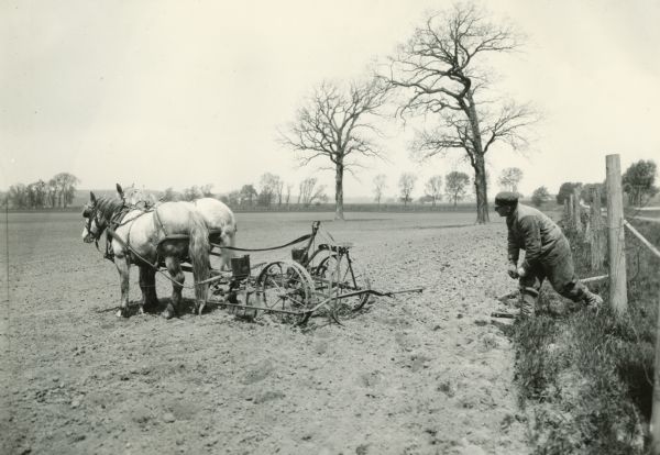 A man changing the check wire while planting corn on Bainridge Farm.