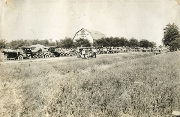 Automobiles parked for a "diversification meeting" at an IH "experiment farm."