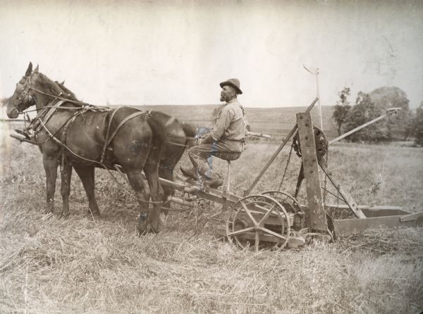 A. Lindemann of Cascade, Iowa, with a horse-drawn McCormick Advance reaper and mower.