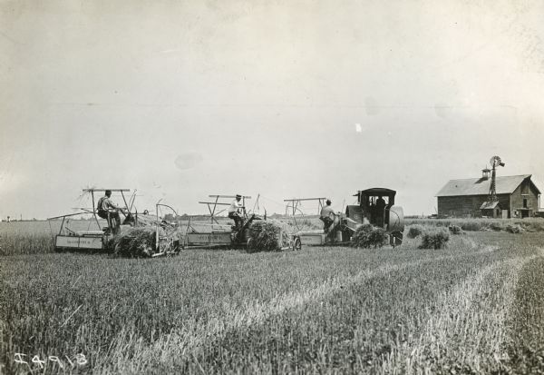 Men operate three McCormick grain binders and a Mogul Jr. tractor.