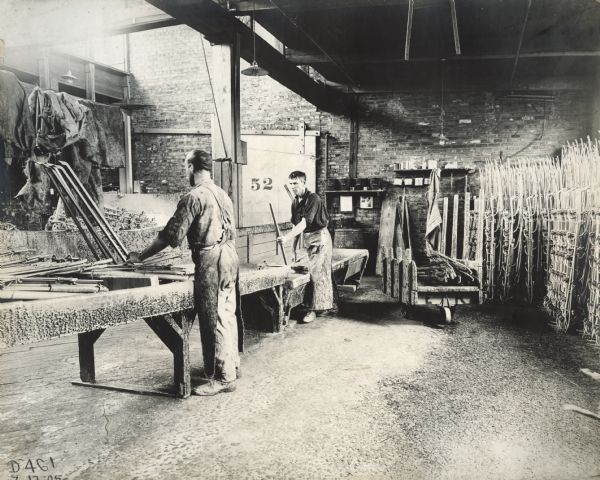 Two men painting parts in the paint department at International Harvester's Deering Works (factory).