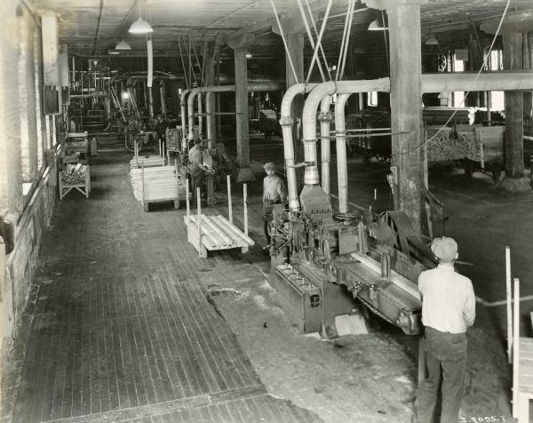 Elevated view of factory workers sawing lumber for trucks at International Harvester's Springfield Works.