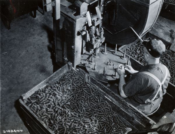 Overhead view of a factory worker working with springs at International Harvester's Rock Falls Works.