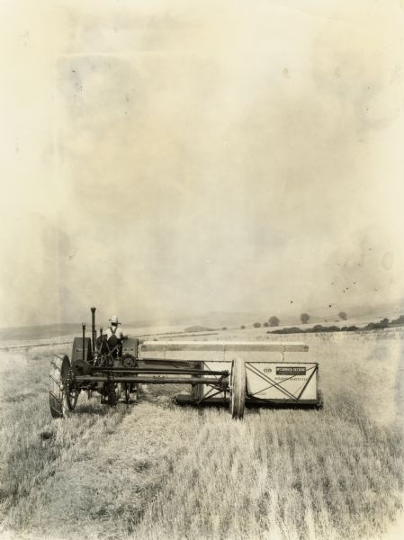 Farmer operating the 12-foot ground drive windrow-harvester.