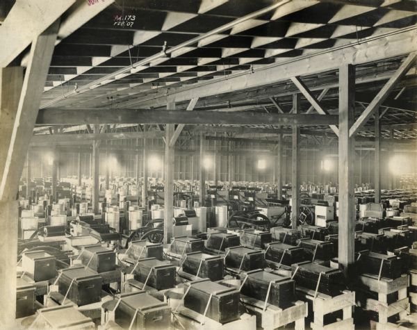 Elevated view of crates on a factory floor at International Harvester's Milwaukee Works. The crates may contain stationary engines. The text on the wooden crates in the foreground reads: "Battery in Separate Package."