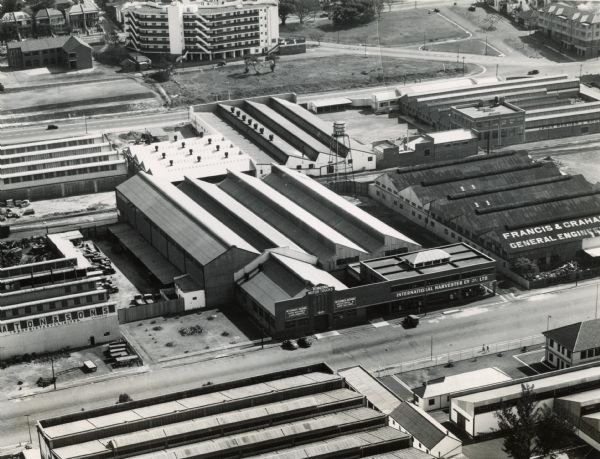 Aerial view of the International Harvester Company building and surrounding industrial area in Durban, Natal, South Africa. The building is located in the center, and is surrounded by (clockwise from upper left) Skinner, Thomas, & Company (plywood manufacturers), the Corrugated Containers Pty. Ltd. (cardboard box manufacturers), Lewis Berger & Sons (paint manufacturers), Francis & Graham (engineers), Dunlop Tire & Rubber Company S.A. Ltd. (manufacturers of Dunlop and Goodyear tires, tubes, belting, etc.), Farmers' Co-Operative Union (wool stores), and J.K. Eaton & Sons (engineers).