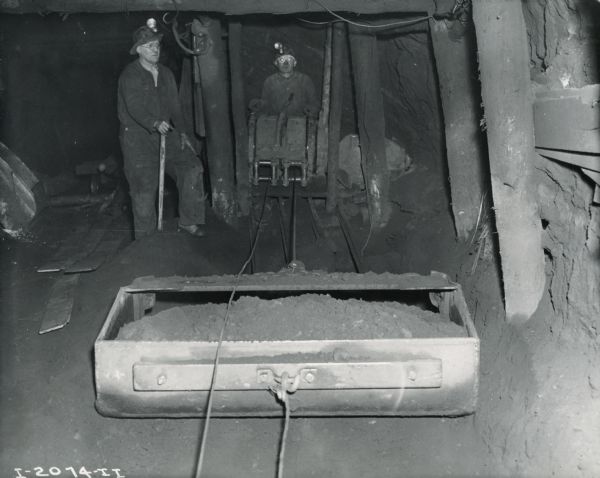 Two workers in coveralls and hardhats underground at International Harvester's Hawkins Mine near Hibbing, Minnesota.