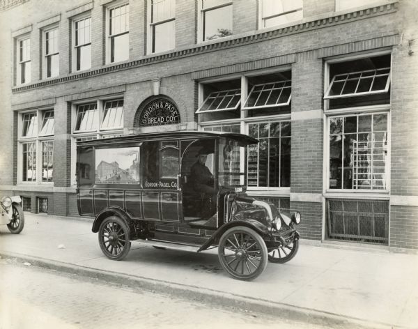 A driver sits in an International truck owned by the Gordon-Pagel Bread Company, possibly in Detroit.