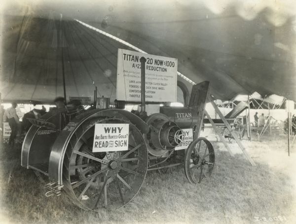 The Titan 10-20 tractor on display under a large tent with signs explaining its gold painting and new reduced price.