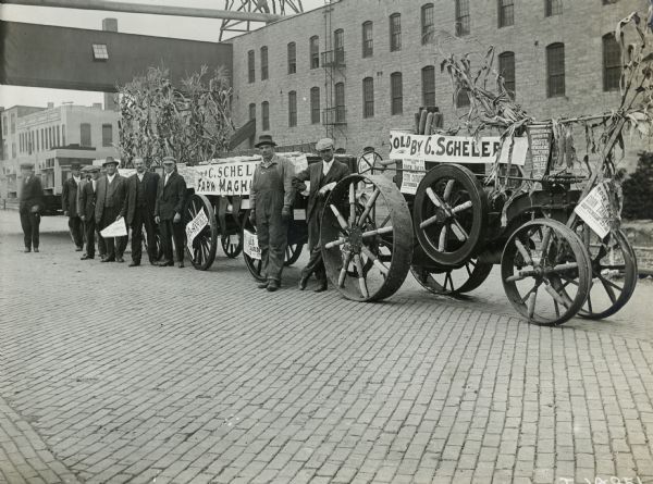 Men with a Mogul 8-16 tractor and wagons on a cobblestone street. The group is probably preparing for the Rock Falls Annual Corn Carnival, which took place in September.