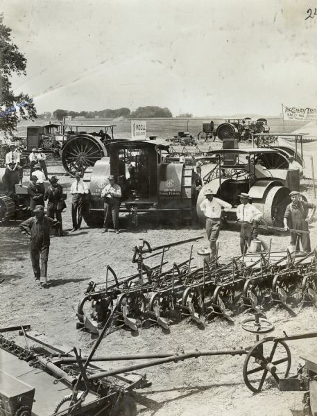 A few men stand around the International Harvester Mogul 30-60 tractor, other tractors and an assortment of farm implements. The men are likely at the "Fremont Tractor Show" near Des Moines, Iowa.