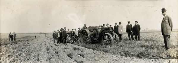 A crowd gathers around a plowing demonstration with an International Harvester Mogul 8-16 tractor.