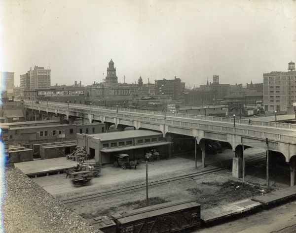Bridge and rail yard near an International Harvester branch house in downtown Des Moines, Iowa. The branch house building is in the distance.