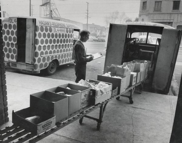 Dispatcher Bud Hufford loading groceries onto one of seven International Metro trucks owned by Hazan's Telphone Supermarket.