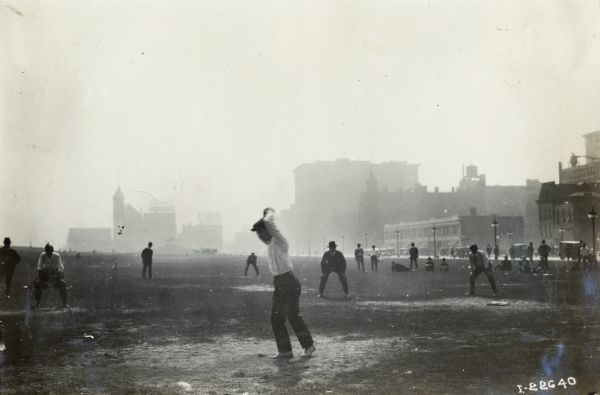 Men, possibly employees of International Harvester, playing baseball in a city park. The park appears to be Grant Park in Chicago, which was located across the street from the International Harvester offices.