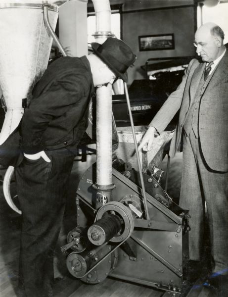 W.R. Jens, Branch Manager, and J.C. Kohlmeyer, Assistant Branch Manager in Milwaukee, look over an International Harvester No. 1-B Hammer Mill.
