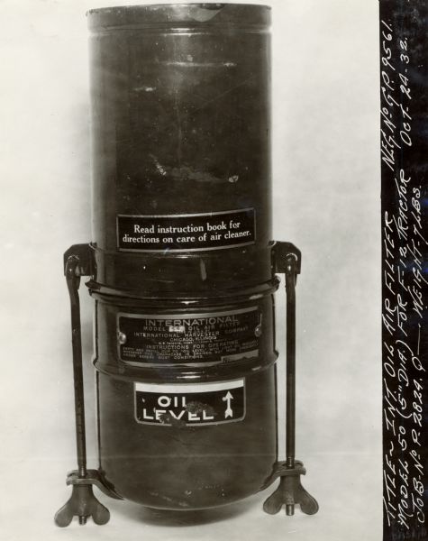 Engineering photograph of an International "oil air filter model 50" for the Farmall F-12 tractor, showing identification plate and decals.