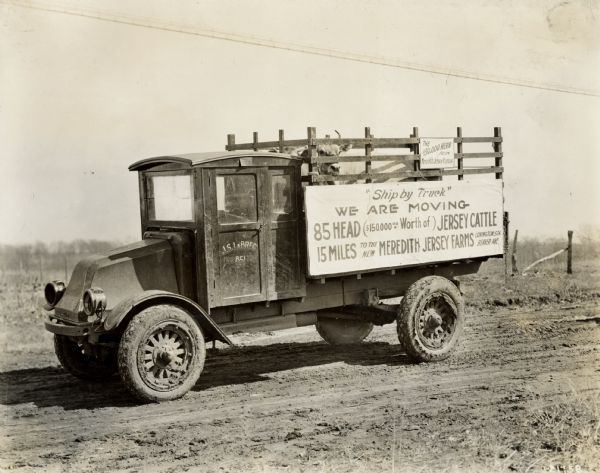 An International G-61 truck rigged for the shipping services of Meredith Jersey Farms. The sign on the side of the truck reads: "Ship by Truck; We Are Moving 85 Head ($150,000 Worth of) Jersey Cattle; 15 Miles to the New Meredith Jersey Farms."
