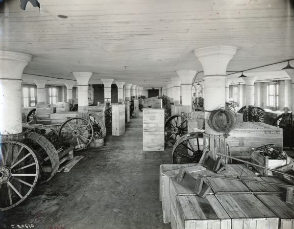 Wooden crates and wheels in a large room at International Harvester's Milwaukee Works (factory).