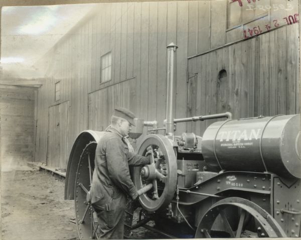 A man works on a Titan 10-20 tractor outside International Harvester's Milwaukee Works (factory).