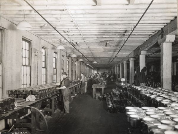 Workers handling long rows of parts at International Harvester's Milwaukee Works.