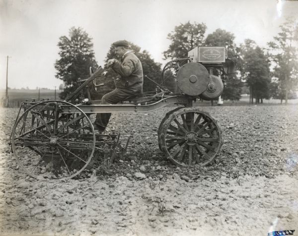 A man operates an experimental motor cultivator in a field.