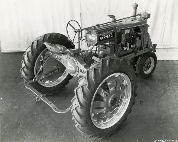 Elevated three-quarter view of right side of a Farmall F-20 tractor with rubber (pneumatic) tires, showing decals on side and under tractor seat.