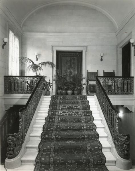 Front entrance hall at Cyrus McCormick, Jr.'s residence at 50 East Huron Street, with marble stairs and Cael stone walls. The view is from the ground floor to the first floor. The door at the top of the stairs leads to the Tapestry Room; the door on the right is to the Main Hall.