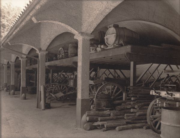 Worksheds filled with stacked logs and wagons at "Walden", the estate of Cyrus McCormick, Jr.