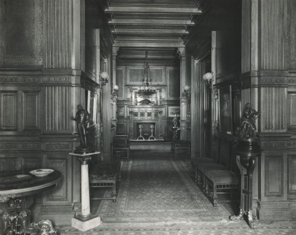 Ornately decorated hallway leading to a room with a fireplace at the McCormick family residence on Rush Street. The house was built for Cyrus Hall McCormick and his family in 1879. After McCormick's death in 1884, the house was occupied by his widow Nettie Fowler McCormick. The photograph is taken from a photograph album entitled "The Old Home".