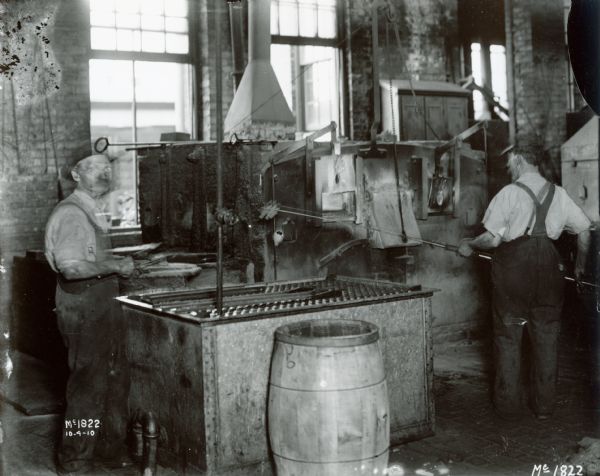 Two workers forging(?) parts at International Harvester's McCormick Works.