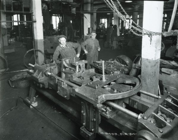 Factory workers posing near parts and machines at International Harvester's Osborne Works (later known as "Auburn Works").