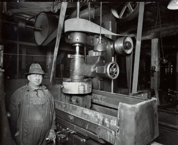 Factory worker standing near machinery at International Harvester's Osborne Works (later known as Auburn Works).