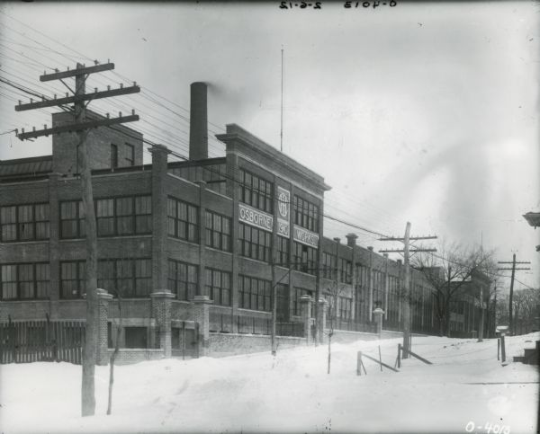 Exterior of International Harvester's Osborne Works (later known as Auburn Works) with a snow-covered street in the foreground.