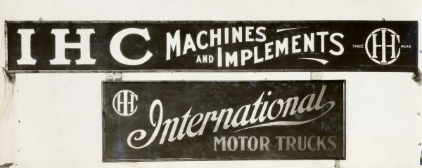 Two large International Harvester signs advertising International Harvester Machines, Implements and Motor Trucks.