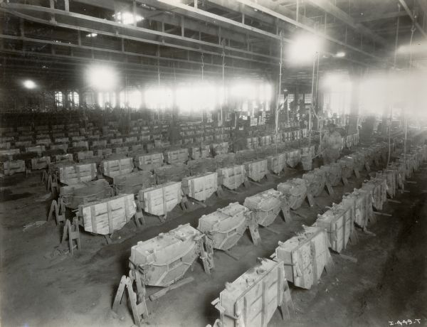 Factory workers walk between rows of molds for machine implement parts at the Chattanooga Plow Works.