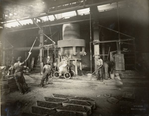 Factory workers around a blast furnace in a foundry at the Chattanooga Plow Works.