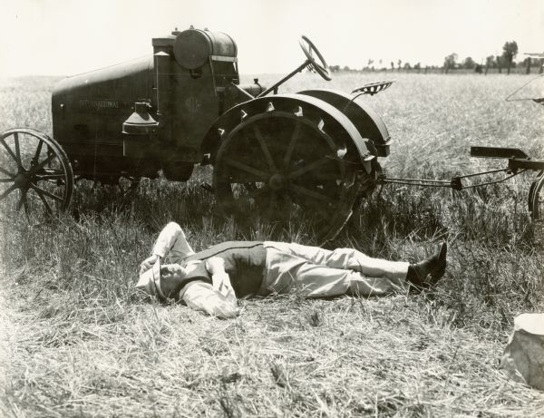 "Mr. Haney" lies down in a field beside an International tractor.