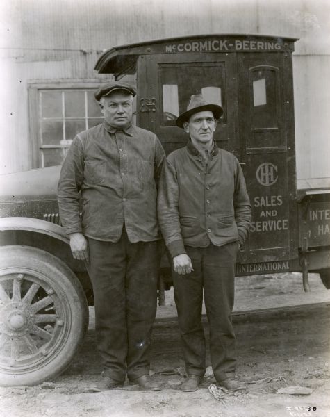 Stewart (left) and Daniels, International Harvester dealers, stand side by side in front of their company truck.