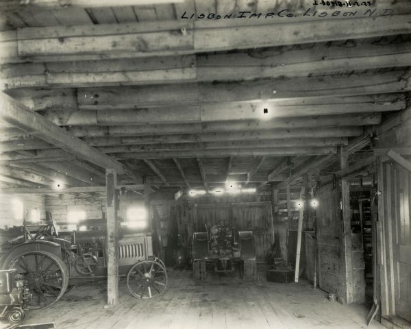 Interior view of several tractors stored within the Lisbon Implement Company, an International Harvester dealership.