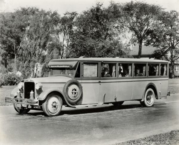 An International bus, 54-H-1, serving as a "Club Coach." The bus is parked and men are looking out of the windows.