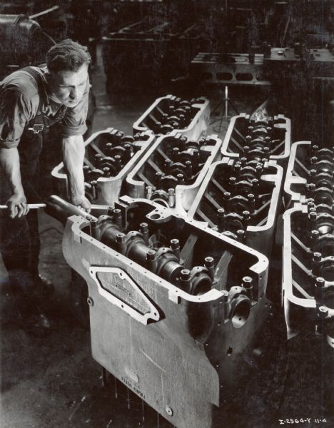 Factory worker reams diesel crankcases in a testing line at Milwaukee Works.