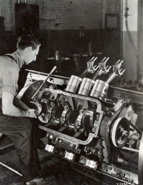 Factory worker tears apart a diesel engine for inspection after run at Milwaukee Works. According to the original caption, each engine received this inspection.