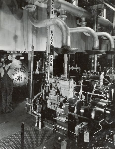 A factory worker electrically records the horsepower of Diesel engines at Milwaukee Works. According to the original caption, each engine was tested in this way. Photograph by Don Jones.