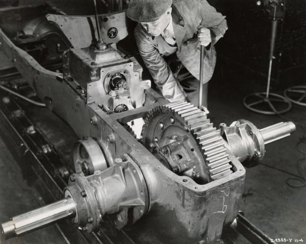 Factory worker assembles bull gear for a WD-40 tractor on an assembly line at Milwaukee Works. Photograph taken by Don Jones.