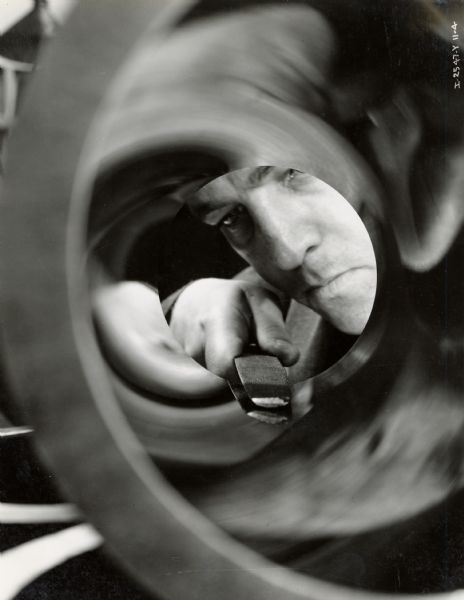 Factory worker tests the file-hardness of a diesel engine cylinder at Milwaukee Works. Photograph taken by Don Jones.