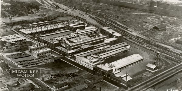 An aerial view of the Milwaukee Works grounds that includes numerous large factory buildings, railways and smaller office buildings.