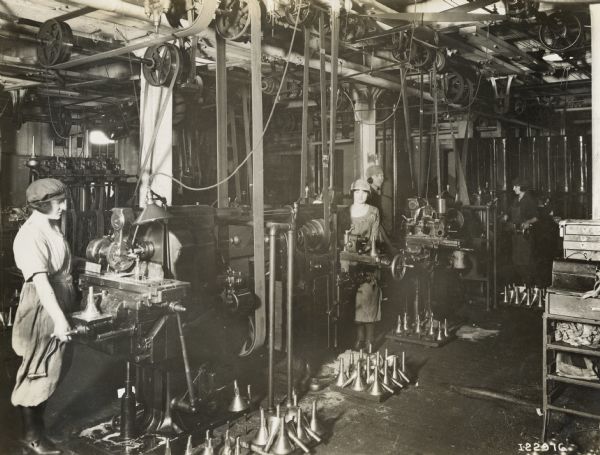 Female factory workers standing at work stations at Milwaukee Works. The women are likely engaged in the manufacture of cream separators.